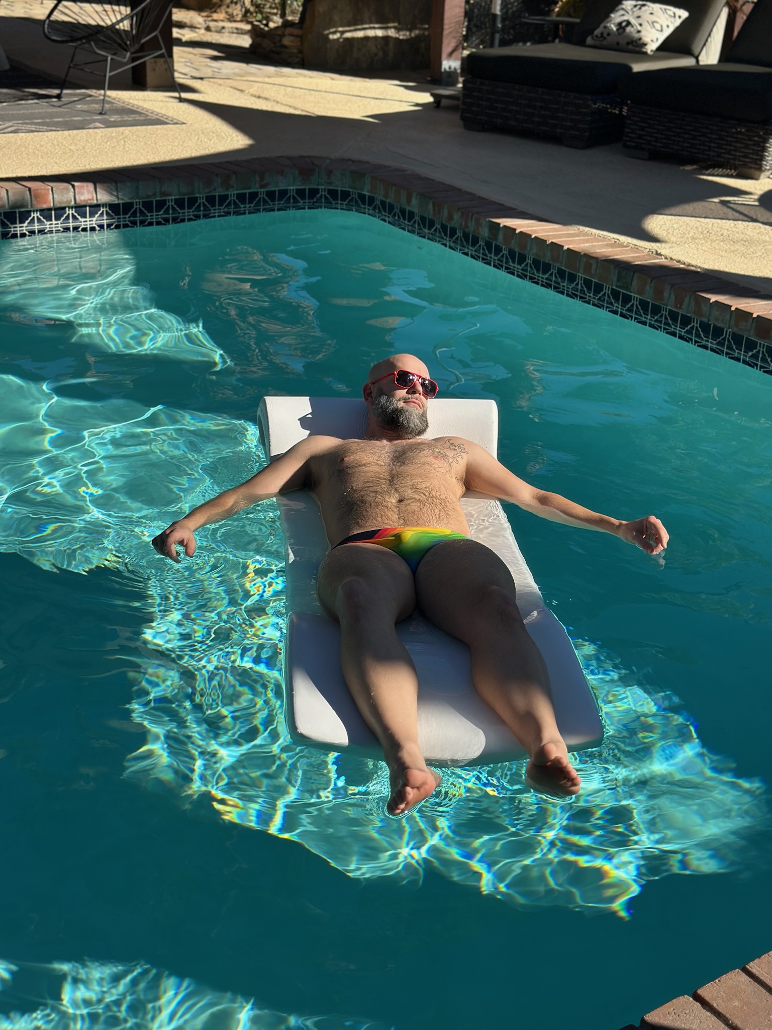 A guest resting on a pool float in the afternoon sun